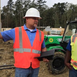 RiskWise safety consultant conducting a job site inspection, discussing safety protocols with a construction worker.