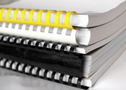 Stack of comb-bound safety manuals representing customized OSHA-compliant written safety programs by RiskWise