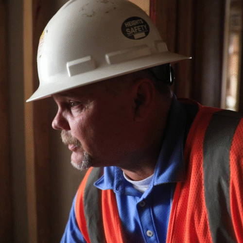 RiskWise Safety Consultant on Job Site Close-up of a RiskWise safety consultant wearing a hard hat and safety vest inside a construction site.